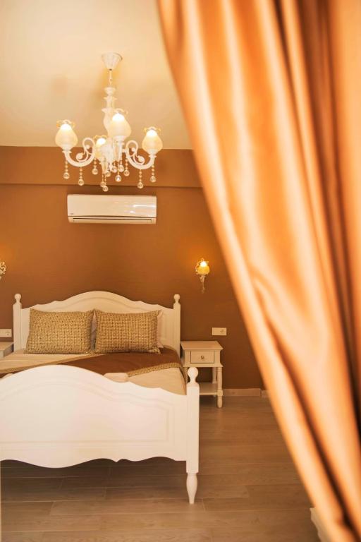 a bedroom with a white bed and a curtain at Selin Hotel in Alaçatı