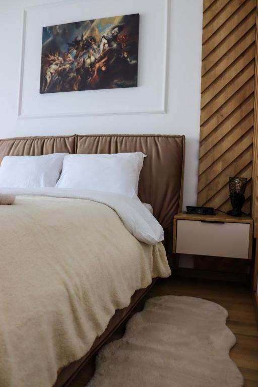 a bedroom with a bed and a painting on the wall at ApArte Suite in Râşnov