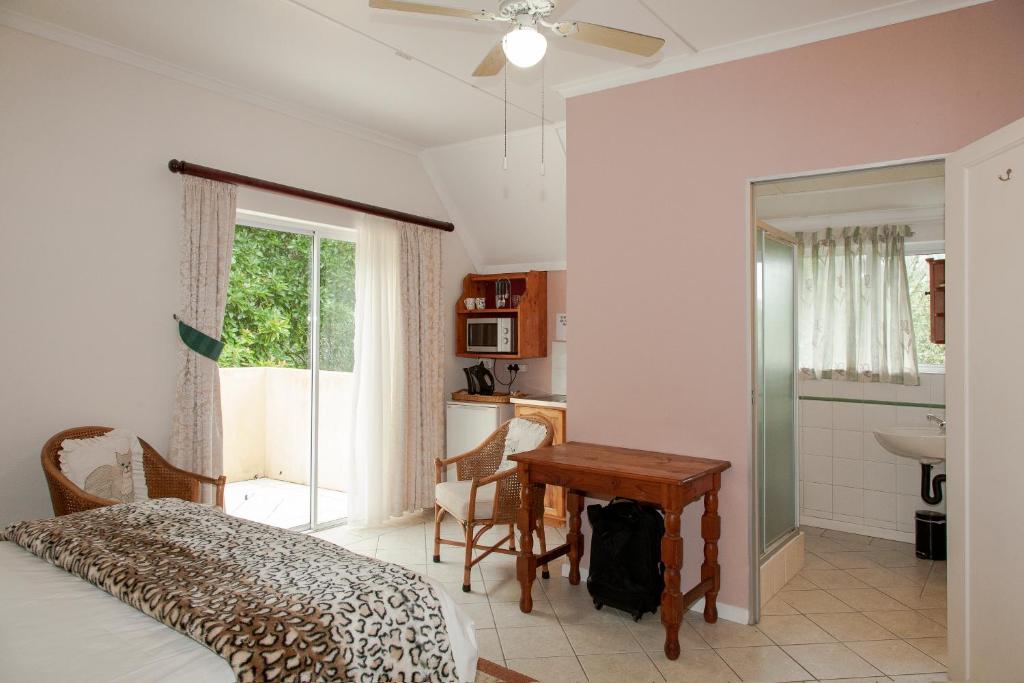 a bedroom with a bed and a table and a sink at York House Guest House in Hillcrest