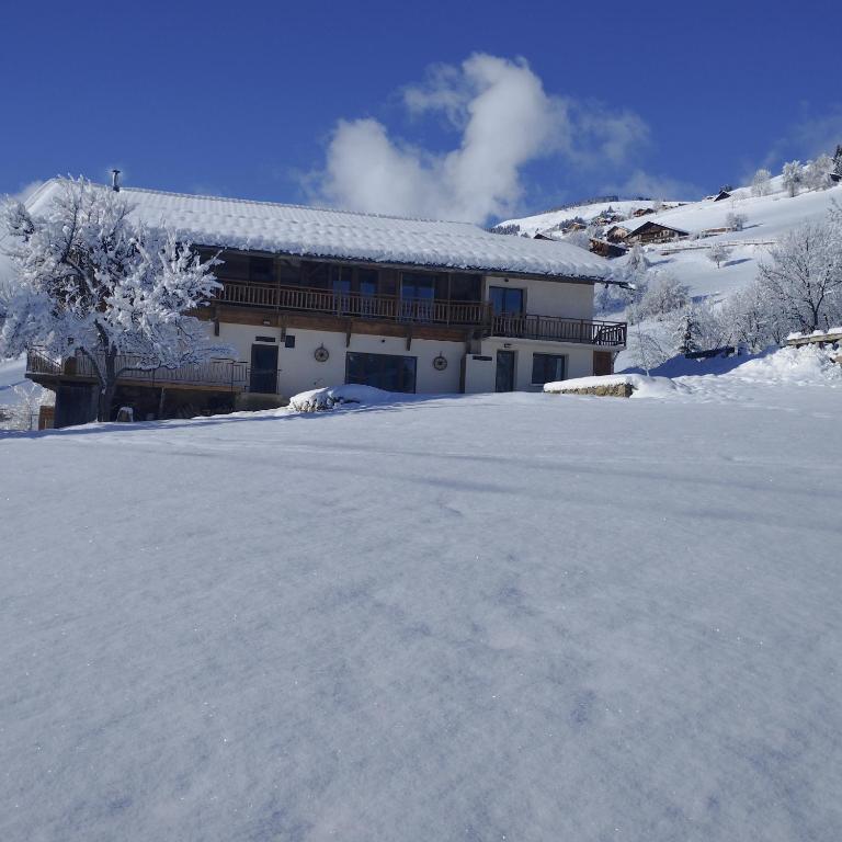 une cour couverte de neige devant un bâtiment dans l'établissement 3 Pièces L'EDELWEISS, à Hauteluce