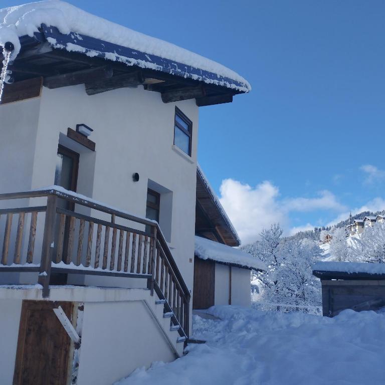 une maison avec un escalier dans la neige dans l'établissement Studio LE MONT, à Hauteluce
