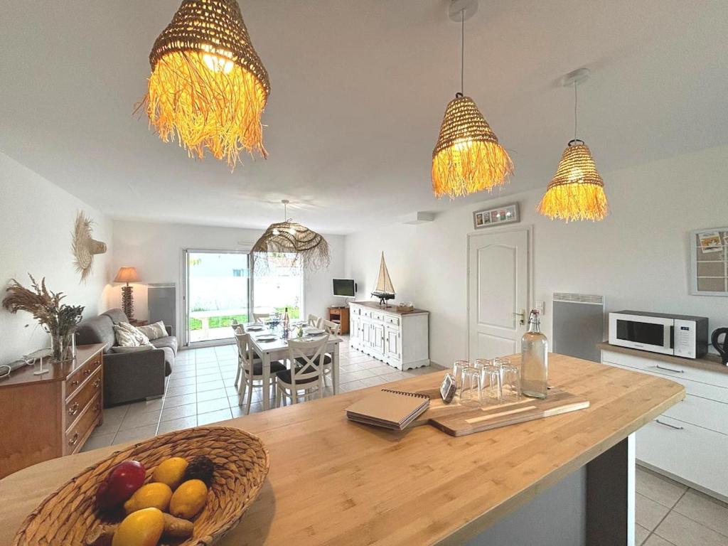 une cuisine avec une table avec un bol de fruits dessus dans l'établissement Coco Sardine, à Saint-Gilles-Croix-de-Vie