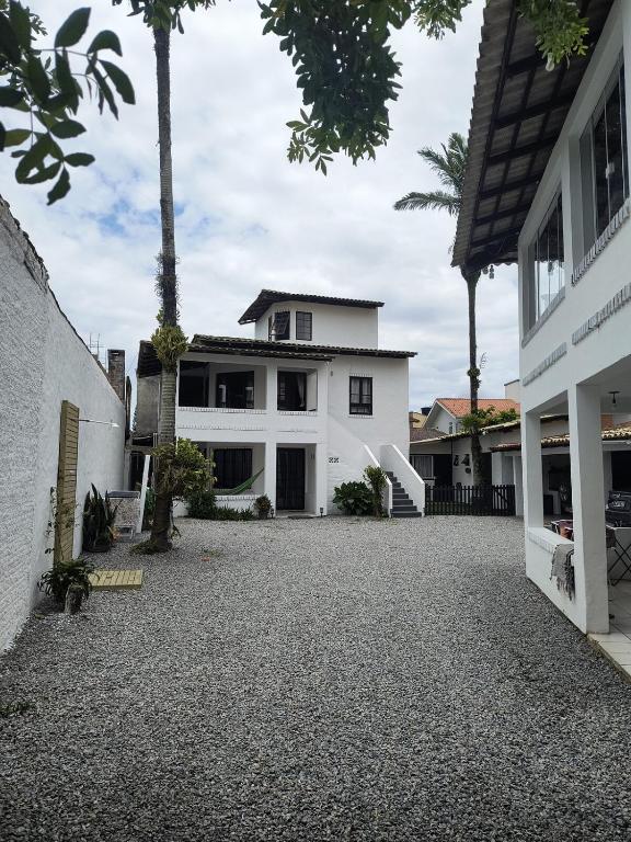 an empty driveway in front of a white house at Pousada Recanto das Palmeiras in Florianópolis