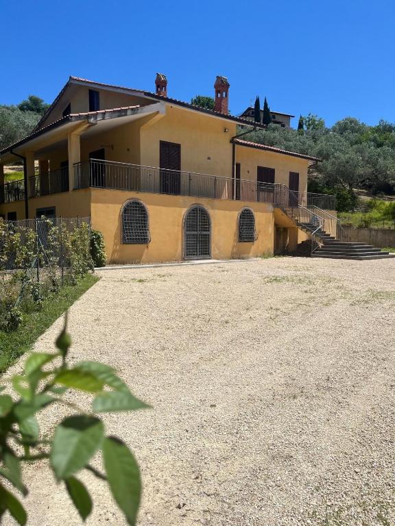 a large yellow house with a large driveway at Casa di Farfa in Castelnuovo di Farfa
