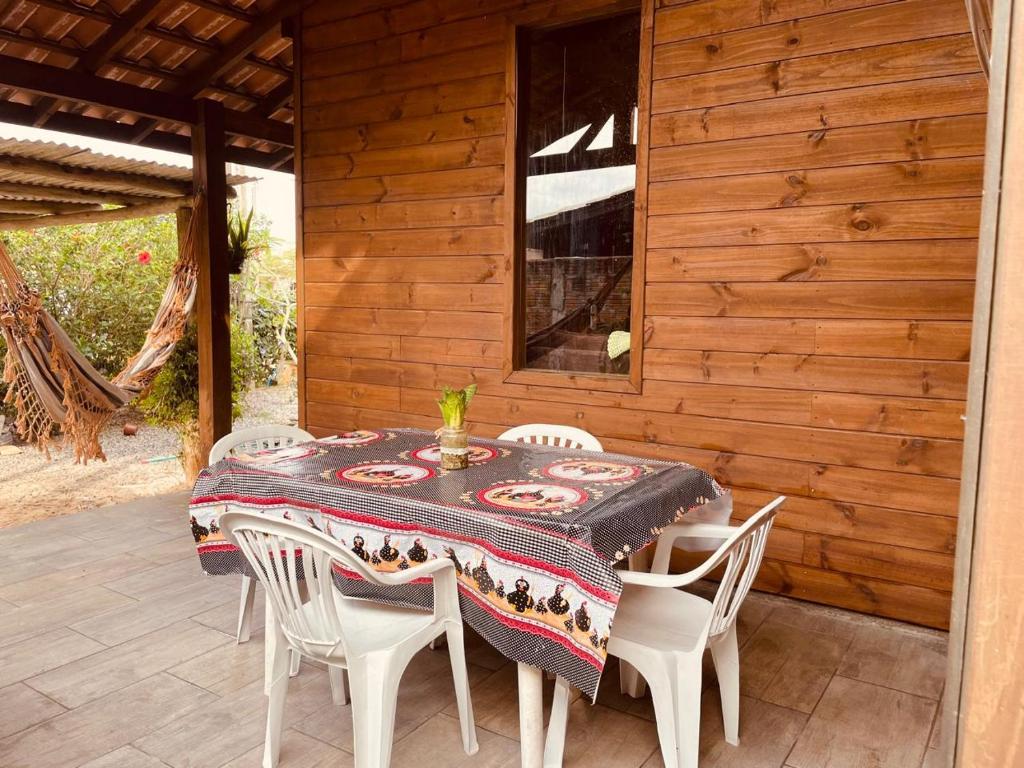 a table and chairs sitting on a porch with a table and chairs at Cabanas dos Sonhos 2- Barra de Ibiraquera in Imbituba