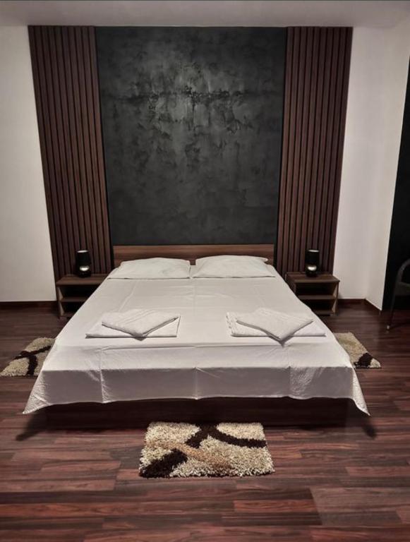 a bedroom with a large bed with a painting on the wall at Villa Ramiela in Arad