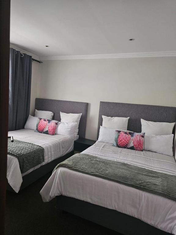 a bedroom with two beds with pink pillows on them at Bedfortgardens in Johannesburg