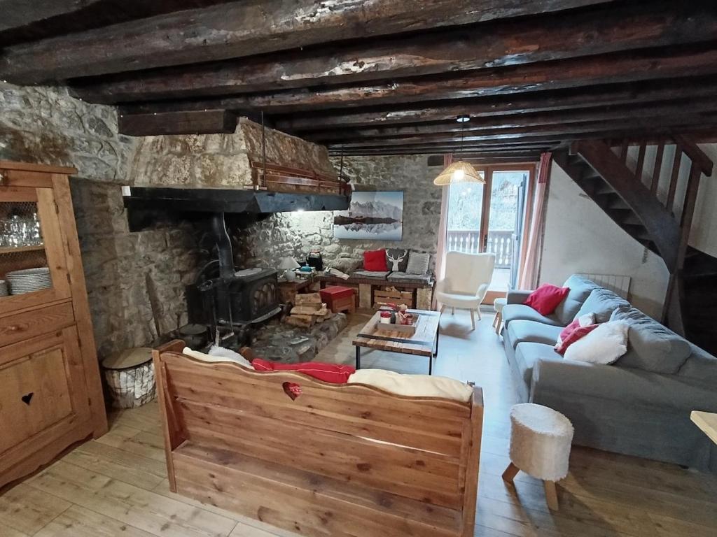 a living room with a couch and a fireplace at La fruitière in Verchaix