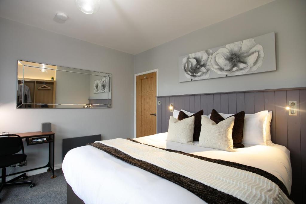 a bedroom with a bed and a desk and a mirror at Entire Luxurious 2 Bedroom Flat in Leicester