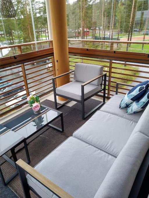 a balcony with a couch and a chair and a table at Kaksio Kivitipun lähellä in Lappajärvi