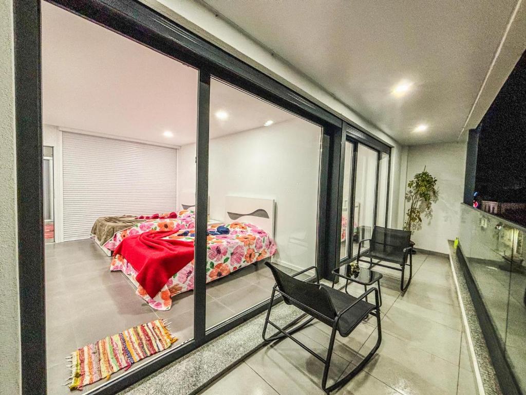 a bedroom with a bed and a large window at Bragança Holiday Home new apartment with 2 bedrooms private parking in Bragança