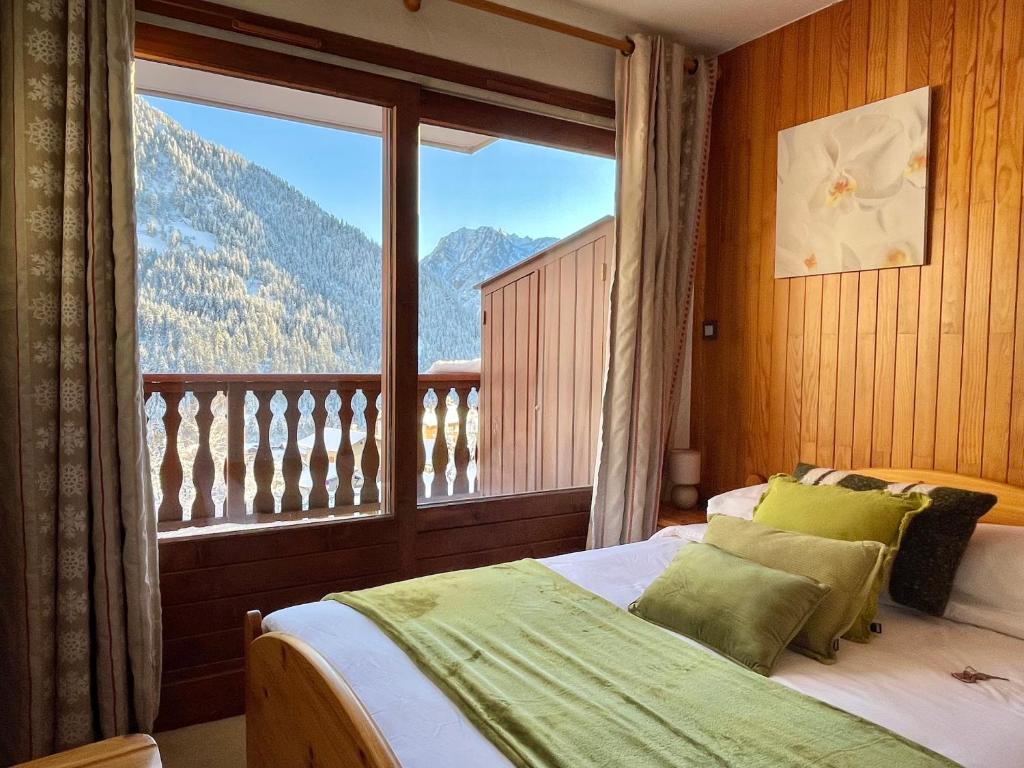 une chambre avec un lit et une grande fenêtre dans l'établissement Appartement Chez Jean - 3 pièces - Champagny-en-Vanoise - La Plagne, à Champagny-en-Vanoise