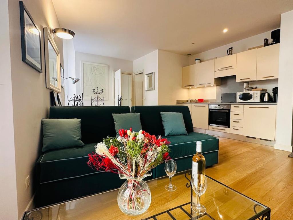 - un salon avec un canapé vert et une table fleurie dans l'établissement New ! Charmant spacieux 2p Vieux-Nice calme, à Nice