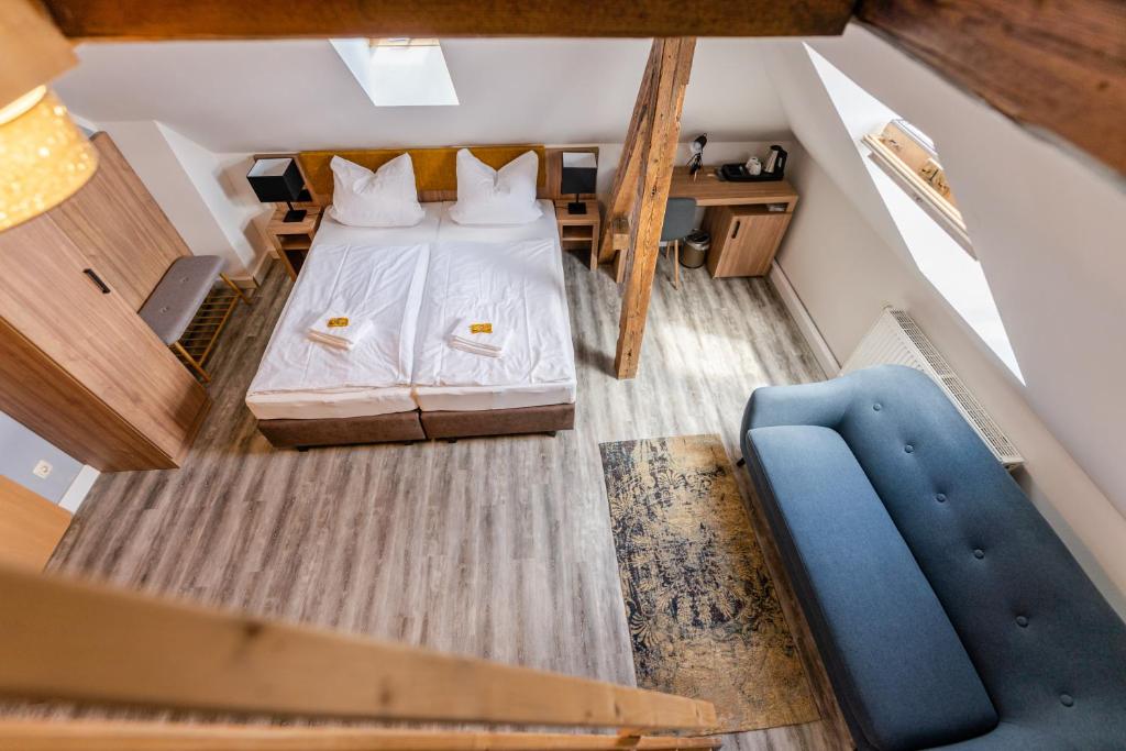 an overhead view of a bedroom with a bed and a blue couch at ElbApartments - Sächsische Schweiz - Ferienwohnungen zum Malerweg - Bastei Urlaub in Pirna