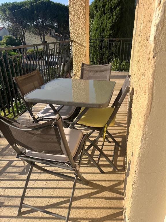 une table et des chaises assises sur une terrasse dans l'établissement T2 lumineux avec Terrasse proche du Tram, à Le Crès