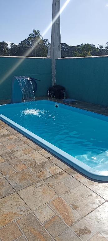 a large blue swimming pool with a water fountain at casa de praia ReJ 2 in Itapoa