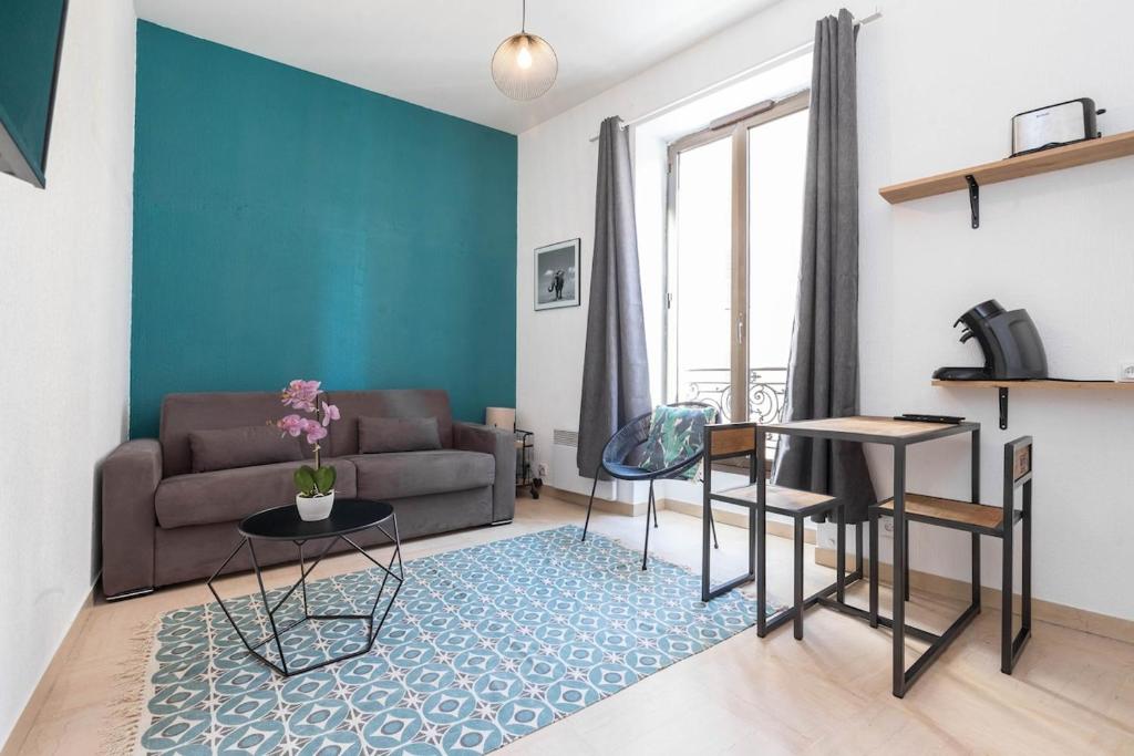 un salon avec un canapé et une table dans l'établissement Superbe studio Nice hyper centre immeuble standing, à Nice