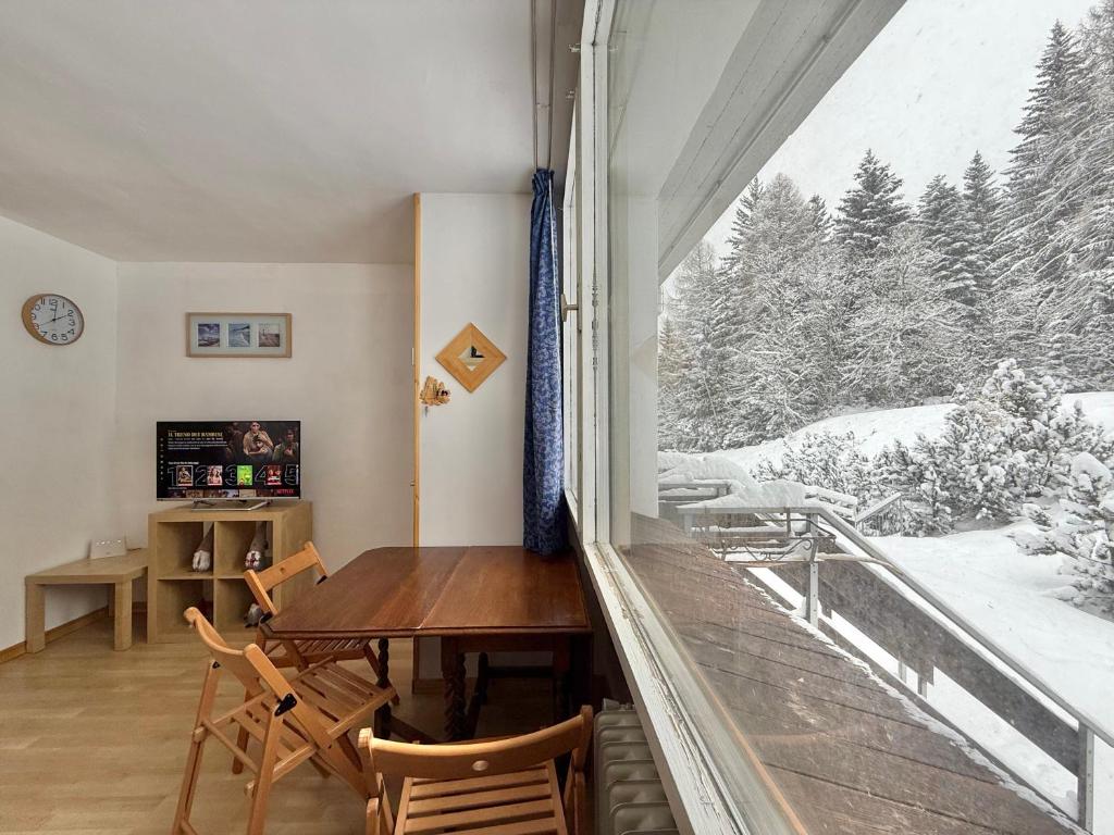 a room with a table and chairs and a large window at Golden Luxe - Fronte pista Comprensorio di Campiglio in Marilleva