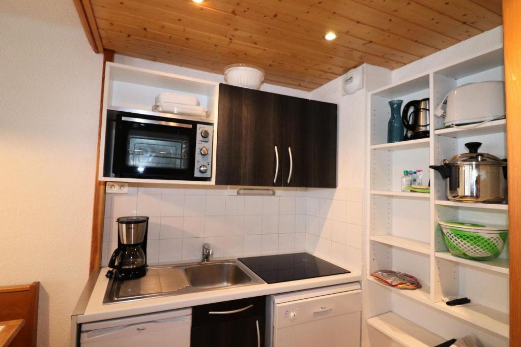 une petite cuisine avec un évier et un micro-ondes dans l'établissement Résidence Hameau Du Borsat 3 - Appartement confortable · Ski au pied MAE-3684, à Tignes