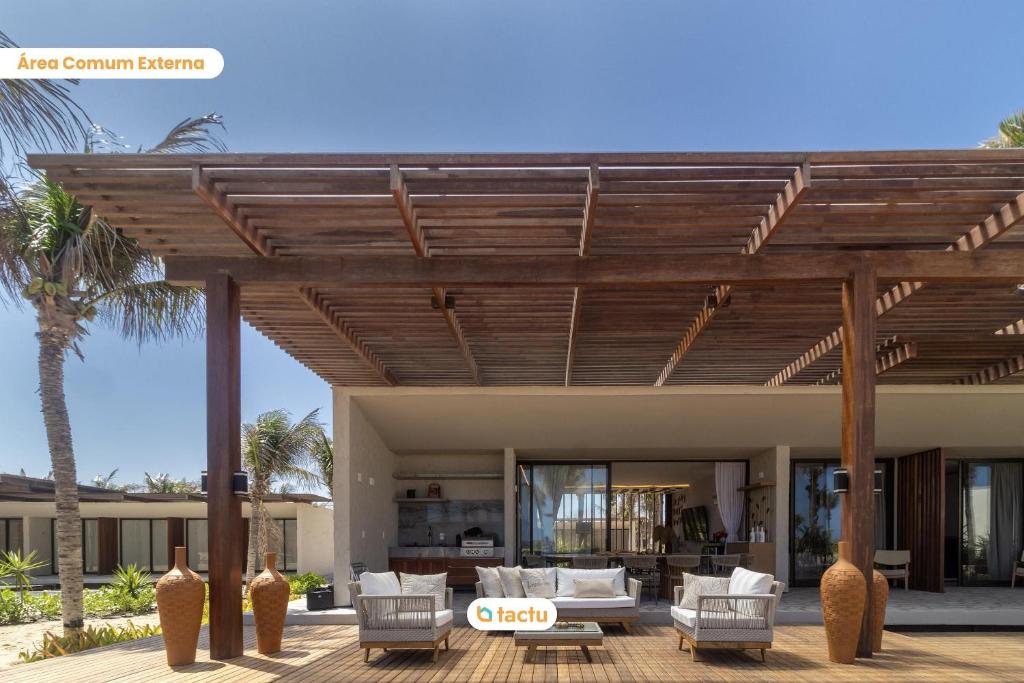 an external view of a house with a wooden pergola at Casa Condomínio Origem Fortim Luxo a Beira Mar in Maceio
