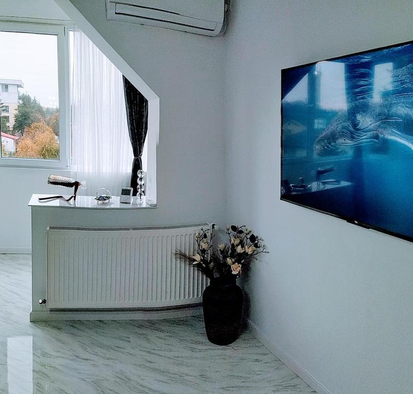 una stanza bianca con un vaso di fiori su un muro di Central Lux 2 camere-parcare gratuita, check-in cifru a Piteşti