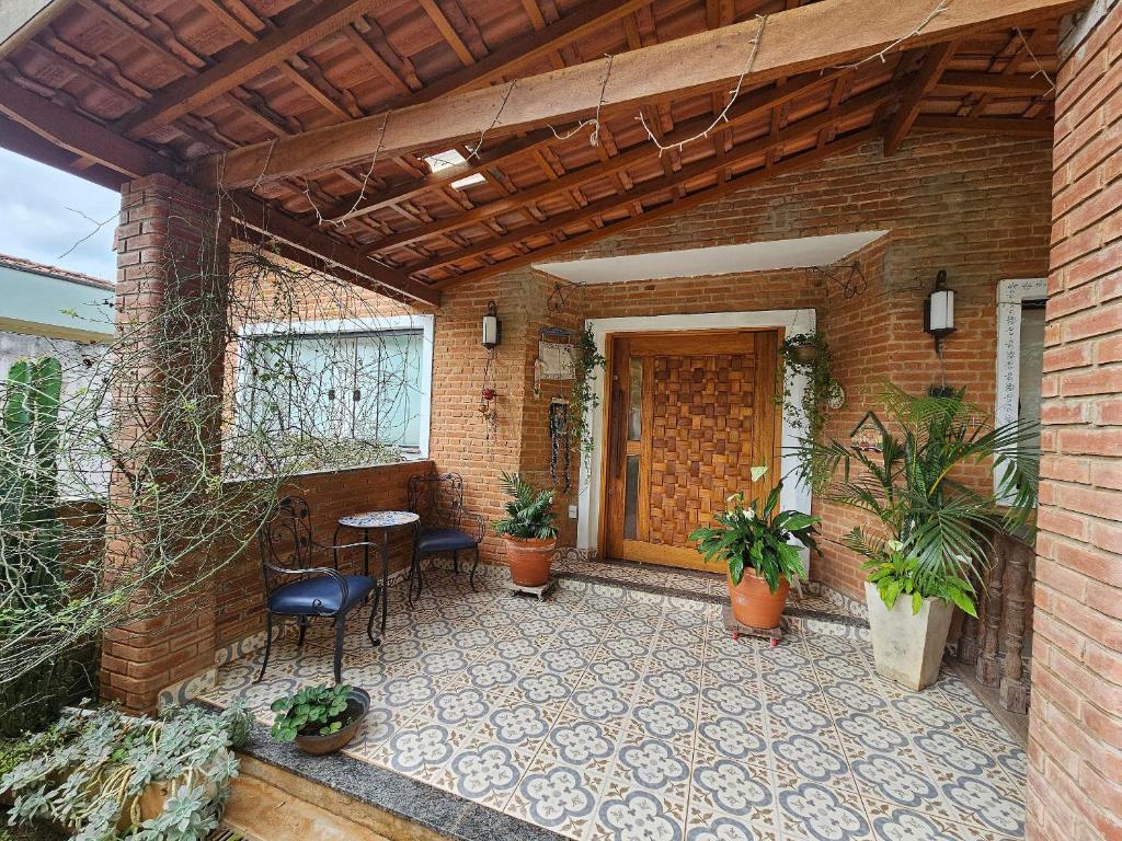 a patio with a table and chairs in a brick building at O Chalezinho Studios - A Casa da Vovó in Serra Negra
