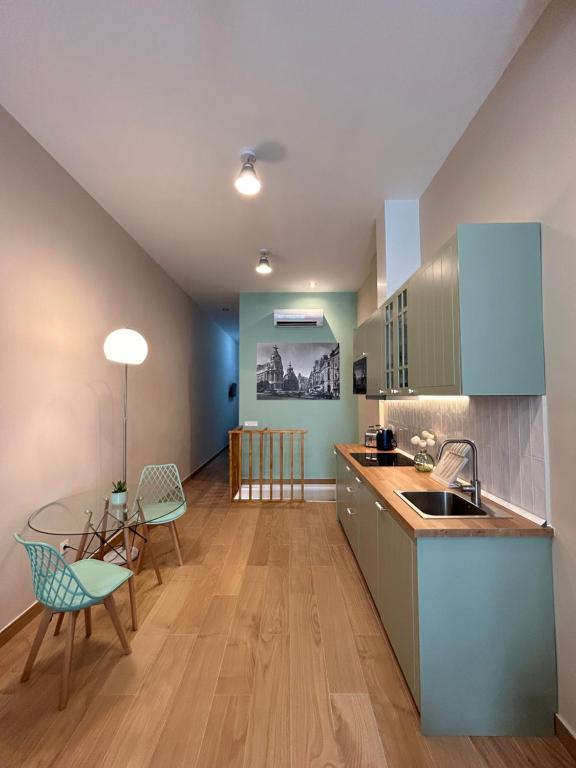 a kitchen with blue cabinets and a table and chairs at Apartamento Centro Madrid Atocha in Madrid