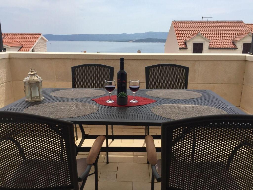 a table with two glasses of wine on a balcony at Apartment Nikola M in Bol