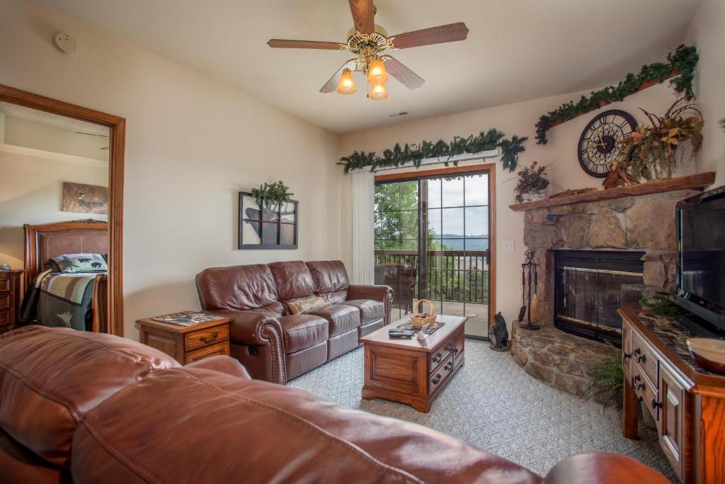 un salon avec un canapé en cuir et une cheminée dans l'établissement 2BR Village At Indian Point 606 near SDC-Free Tickets Daily up to $500 Value, à Branson
