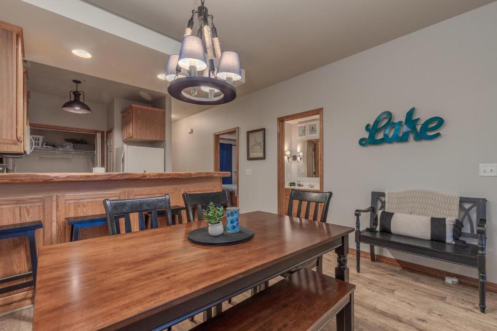 a kitchen and dining room with a wooden table at 2BR Village At Indian Point 604 near SDC-Free Tickets Daily up to $500 Value) in Branson