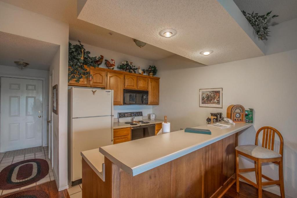 une cuisine avec des armoires en bois et un réfrigérateur blanc dans l'établissement 2BR Village At Indian Point 707 near SDC-Free Tickets Daily up to $500 Value, à Branson