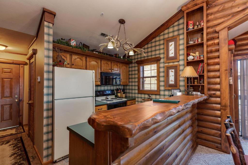 Una cocina con paredes de madera y un refrigerador blanco. en 2BR Village At Indian Point 1009 near SDC-Free Tickets Daily up to $500, en Branson
