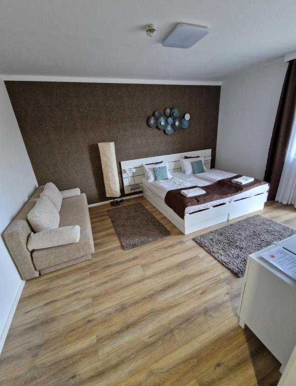 a large bedroom with a bed and a couch at Apartment Sunrise in Zalakaros