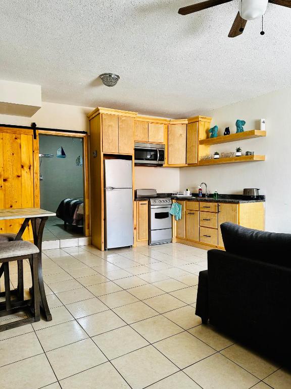 a kitchen with wooden cabinets and white appliances at Rosarito beachside apartment in Rosarito Beach