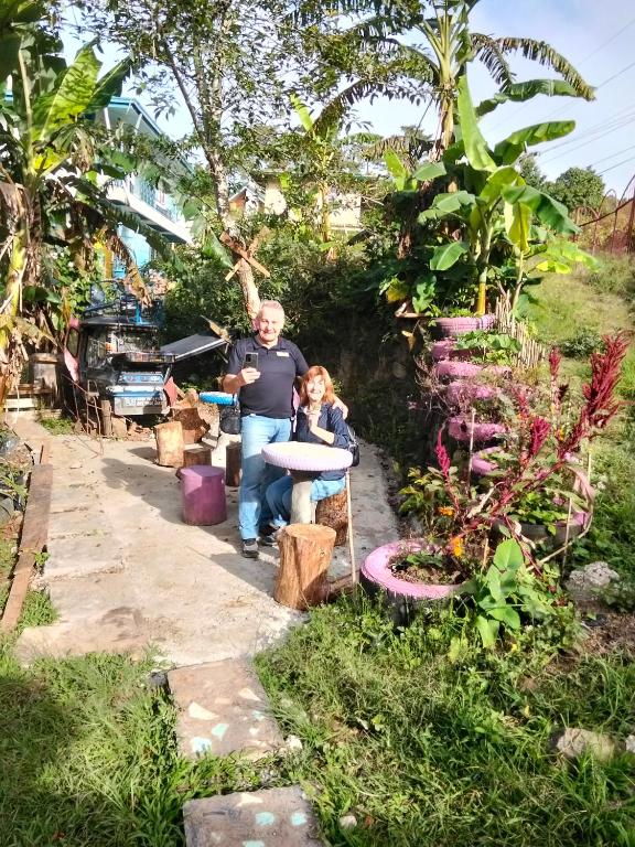 a man and a child standing in a garden at Cbaz bungalow house in Sagada