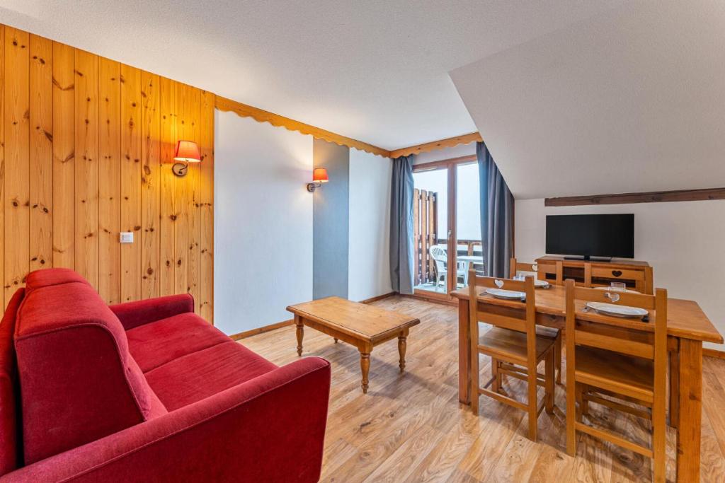 un salon avec un canapé rouge et une table dans l'établissement Résidence Les Hauts De Preclaux - Chaleureux studio avec balcon face aux pistes MAE-4451, aux Orres