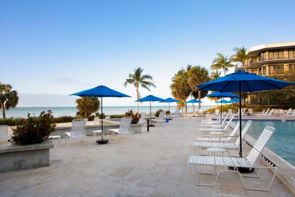 a row of chairs and umbrellas next to a pool at Tranquility by the Beach in Key West
