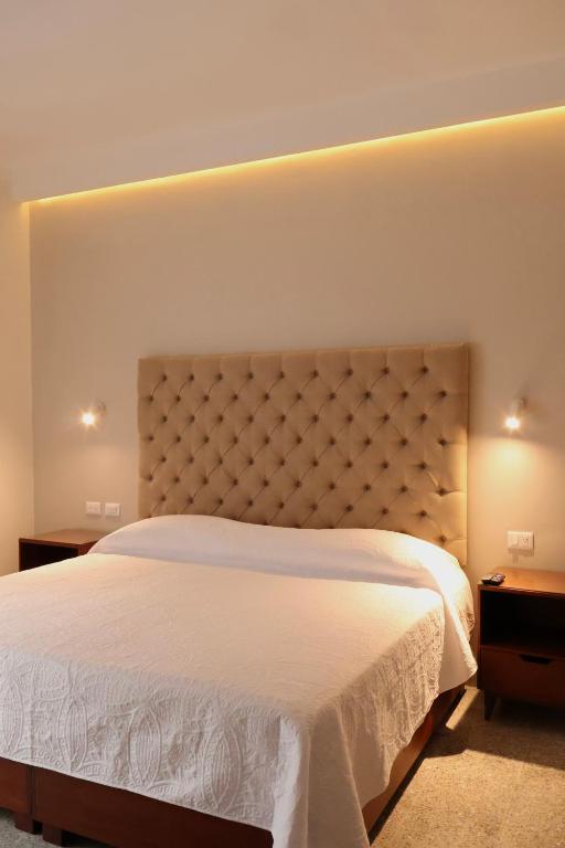 a bedroom with a large white bed and two tables at Casa San José in Coatepec