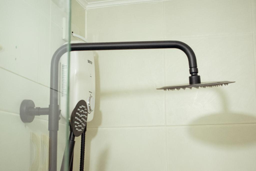 una ducha con cabezal de ducha en un baño en Marina Spatial Studio Condo Unit, en Dumaguete