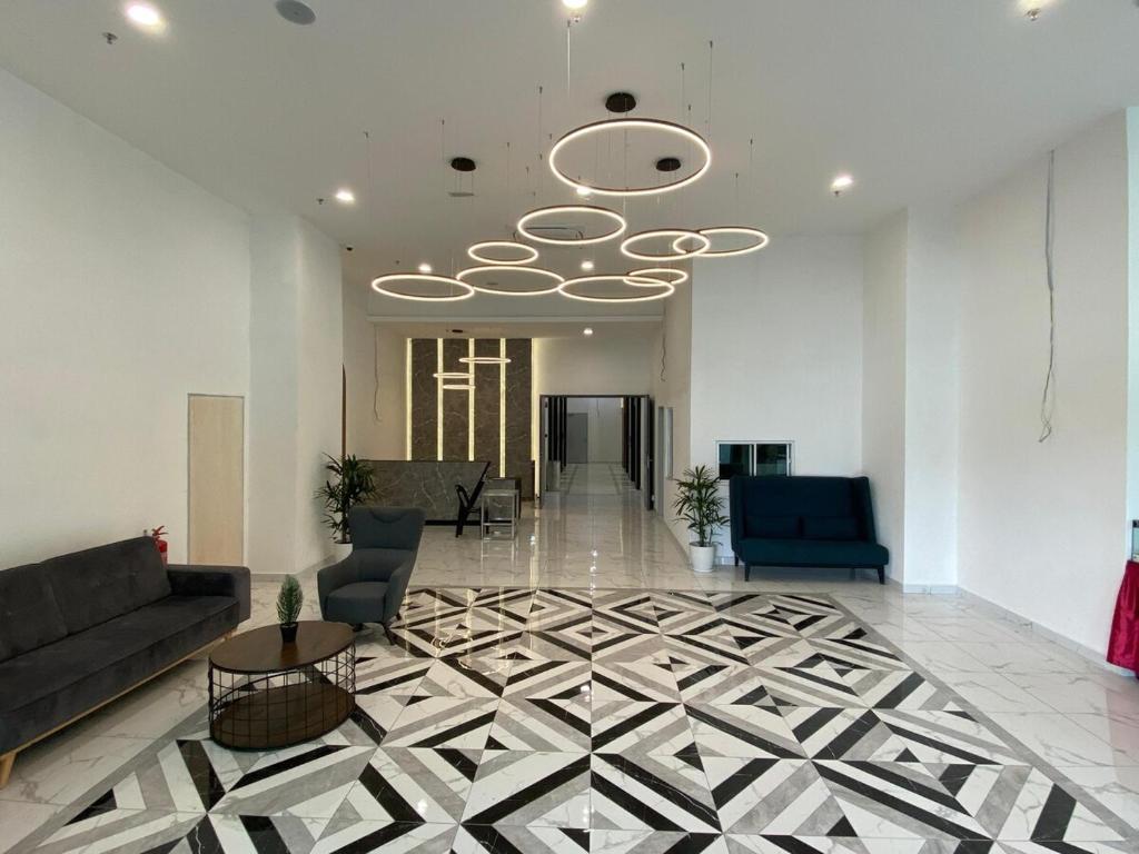 een lobby met een bank en stoelen en een plafond bij Wyndham Garden Suites IPOH ICC in Ipoh