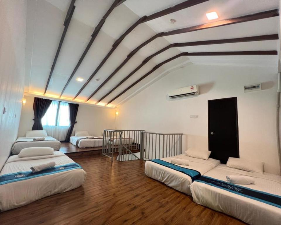 a room with four beds in a room with a ceiling at Swiss Hotel Heritage Boutique Melaka in Melaka