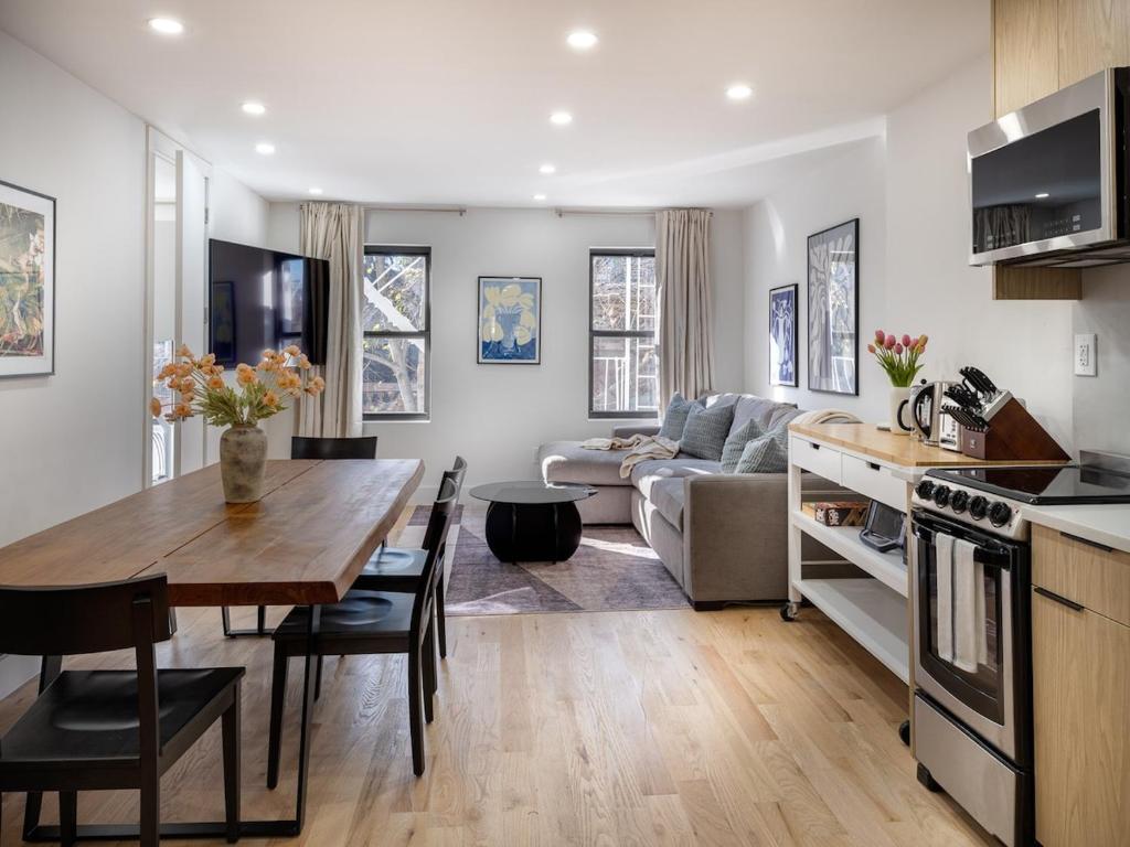 ブルックリンにあるThree-Bedroom Condo next to Bedford Ave L Subwayのキッチンとテーブルとソファのあるリビングルーム