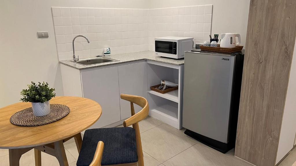 A kitchenette viewed from the dining area, with sink, microwave and refrigerator.
