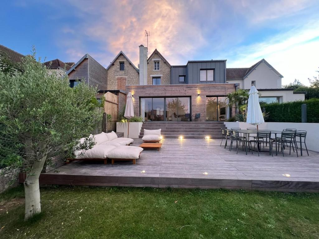 a house with a patio with a table and chairs at La Maison du Nice Caennais in Caen