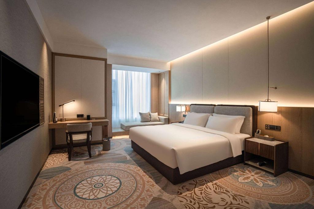 a hotel room with a bed and a television at Howard Johnson by Wyndham Jufu Plaza Jinxi in Fuzhou