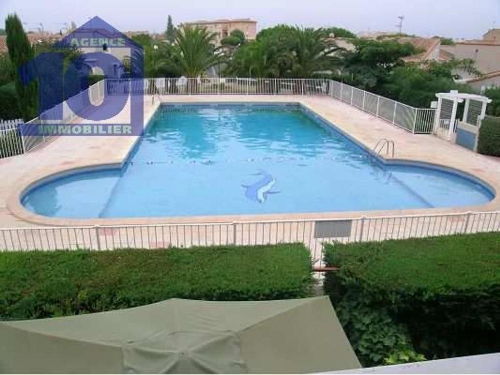 une grande piscine avec un dauphin dans l'eau dans l'établissement Pavillon 5 pers avec piscine, parking et jardin à Valras-Plage - FR-1-781-74, à Valras-Plage