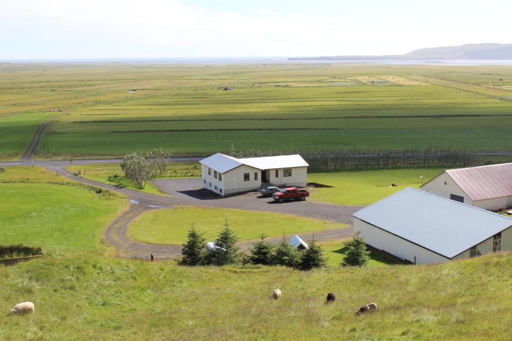 a small white house with a barn on the side of the road at Skammidalur Guesthouse in Vík