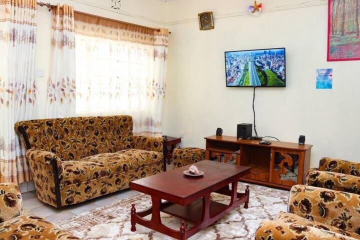 a living room with two couches and a table at Adorable Homely Stay in Nakuru