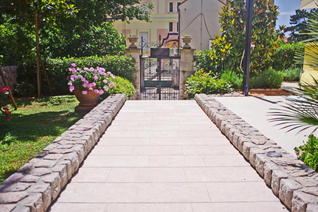 a stone path in a garden with flowers at Guest House Villa Dagmar in Crikvenica