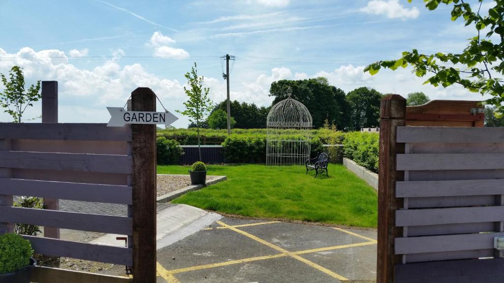 a gate to a garden with a sign on a fence at Hatton's of Garadice in Garadice